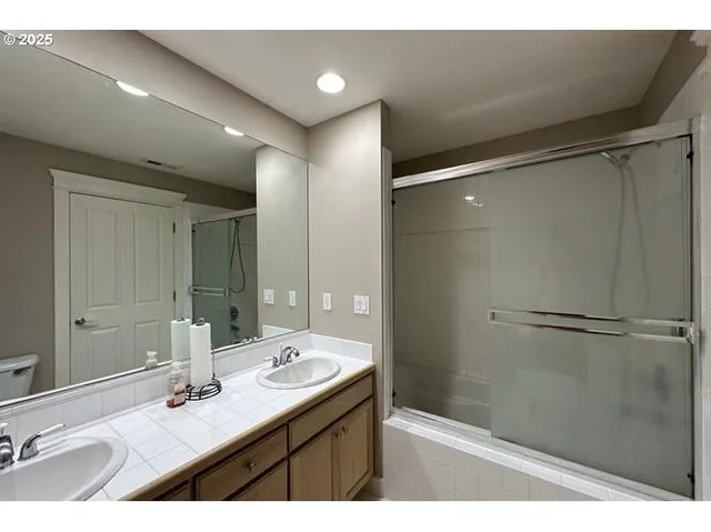 a bathroom with a sink shower and a mirror