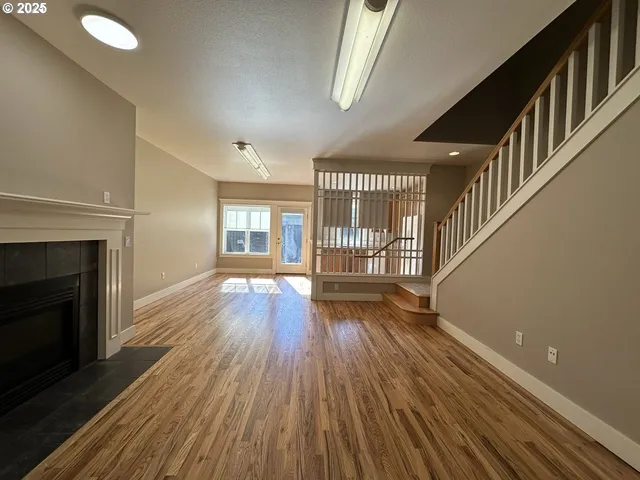 an empty room with wooden floor and fireplace