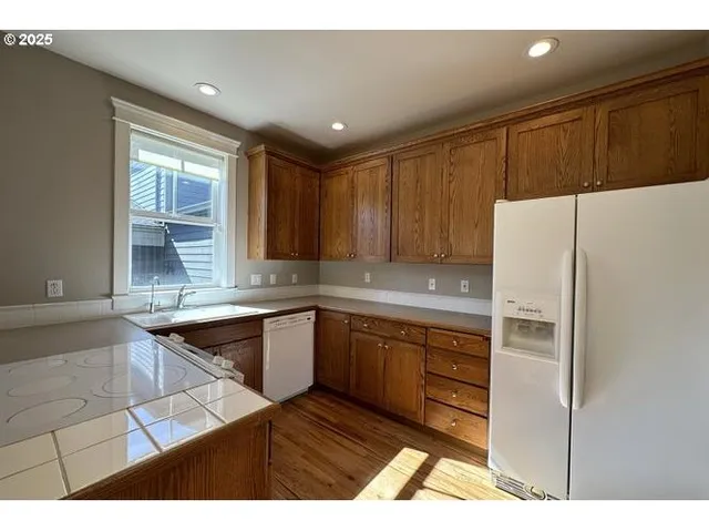 a kitchen with granite countertop a refrigerator and a sink