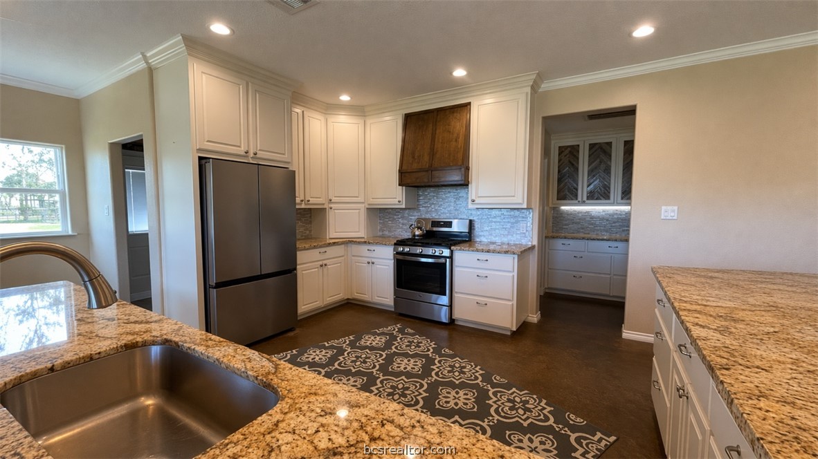 11810 Riley Green Road Franklin, TX 77856 - Photo 9 of 36 a kitchen with stainless steel appliances granite countertop a refrigerator a stove and a sink with wooden floor