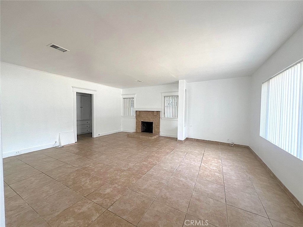 1554 East Woodbury Road Pasadena, CA 91104 - Photo 3 of 13 an empty room with fireplace and windows