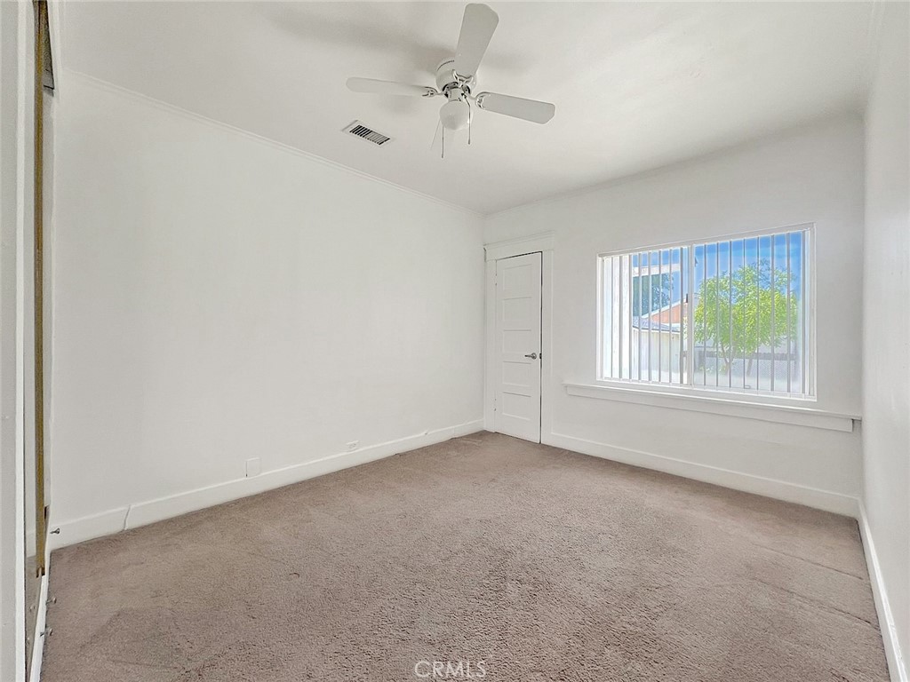 1554 East Woodbury Road Pasadena, CA 91104 - Photo 9 of 13 an empty room with windows and fan