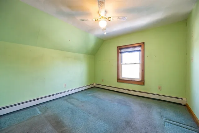 an empty room with a window and a ceiling fan