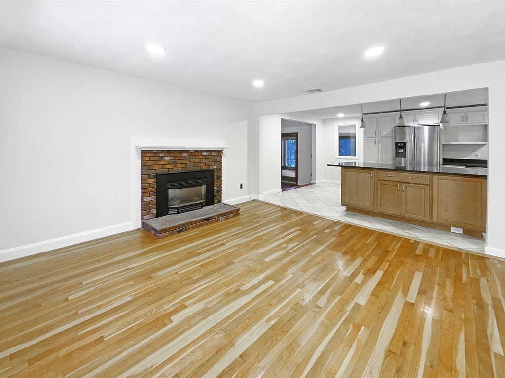 16 Marlyn Road Billerica, MA 01821 - Photo 8 of 34 a view of an empty room with wooden floor and a fireplace