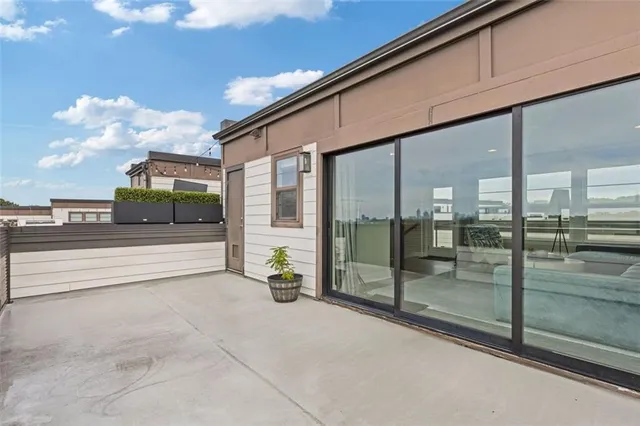 a bedroom with a bed couch and a large window