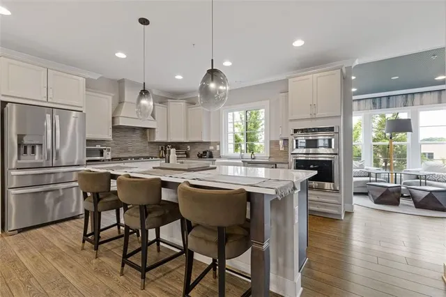 a kitchen with a table chairs refrigerator and wooden floor