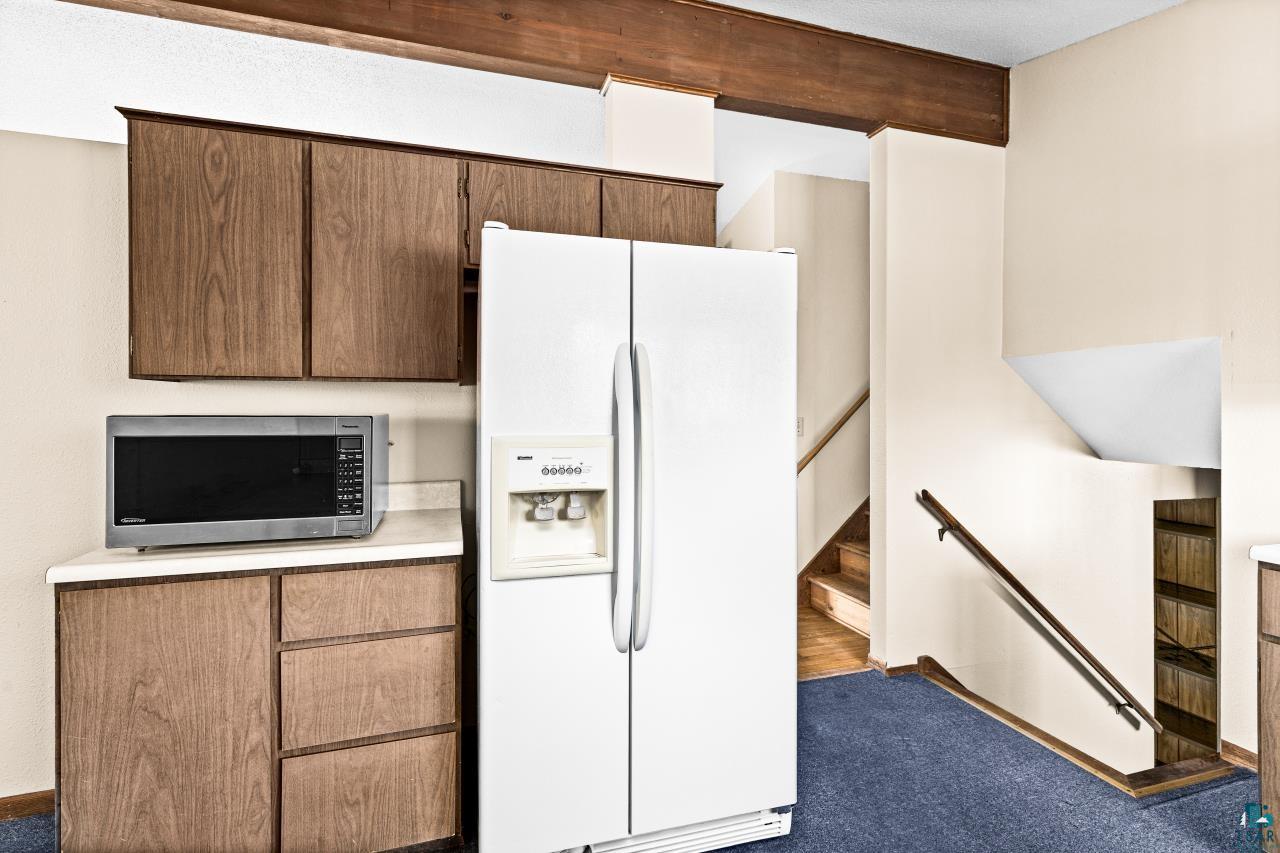 6606 Metso Road Kettle River, MN 55757 - Photo 25 of 84 Kitchenette area featuring wood-finish cabinetry, light countertops, and a white side-by-side refrigerator