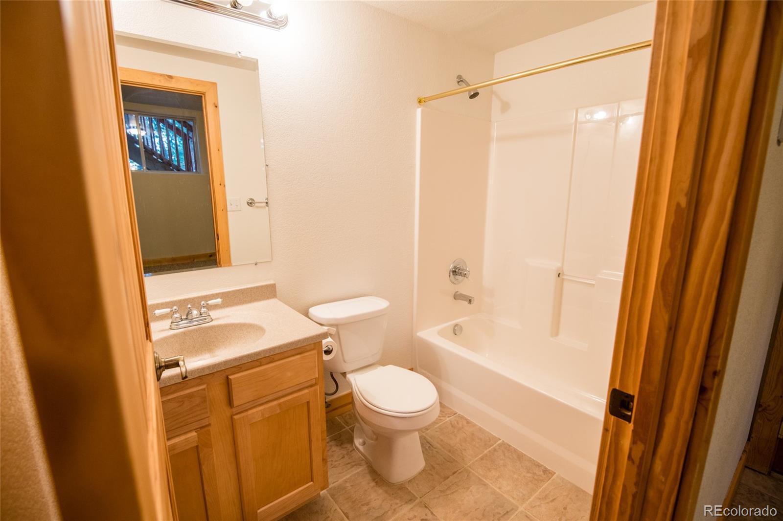 152 Catamount Ridge Road Bailey, CO 80421 - Photo 17 of 27 a bathroom with a granite countertop toilet a sink and a bathtub