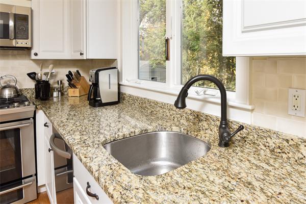 25 Chesterfield Road Milton, MA 02186 - Photo 10 of 27 a kitchen with granite countertop a stove a sink and a microwave