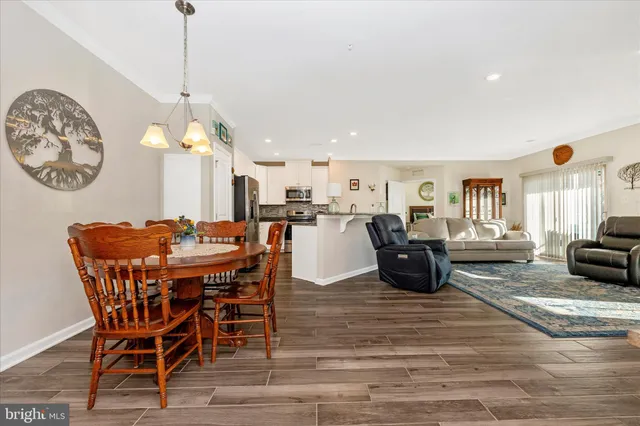 a dining room filled chandelier and wooden floor