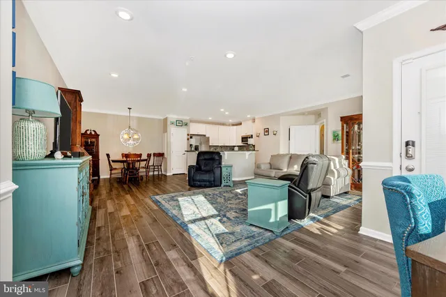 a living room with furniture wooden floor and a kitchen view