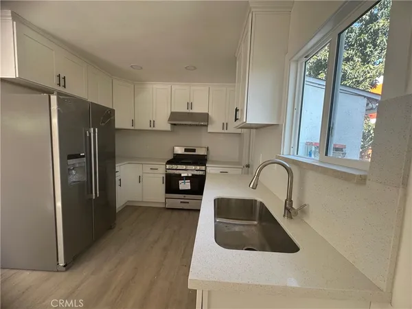 a kitchen with granite countertop a refrigerator and a sink