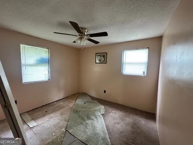 a view of empty room with ceiling fan