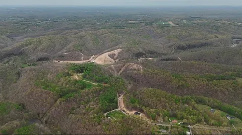 a front view of a house with garden and trees