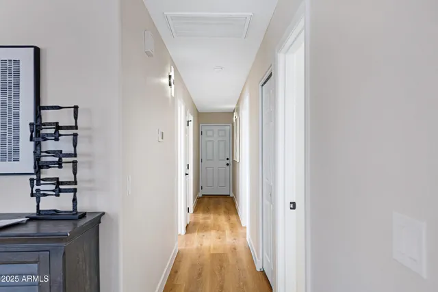 a view of a hallway with wooden floor and staircase