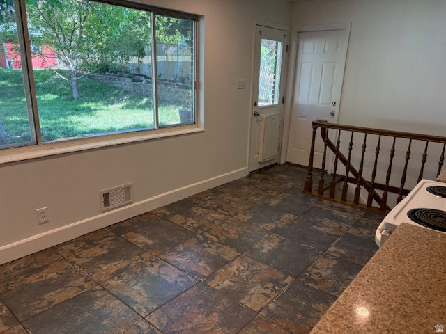 2313 150 East Bountiful, UT 84010 - Photo 12 of 39 Spacious interior featuring large picture windows, multi-toned floor tiling, a white paneled door, and a rich wood-finish railing