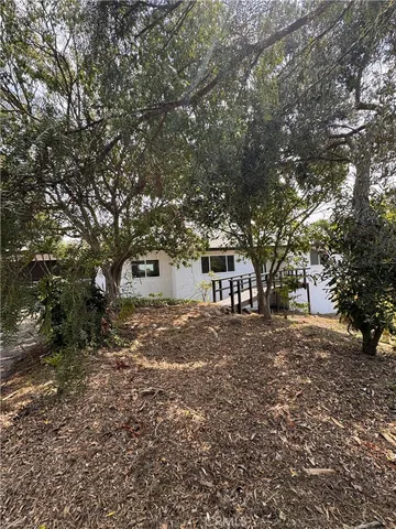a front view of a house with a tree