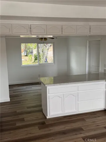 a view of kitchen with wooden floor and cabinets
