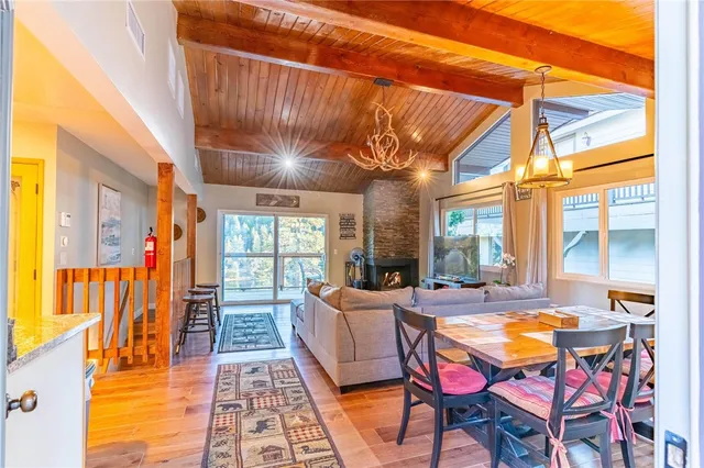 a dining room with furniture large windows and wooden floor