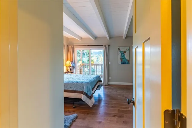 a view of a hallway with wooden floor and windows