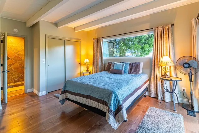 a bedroom with a bed and wooden floor