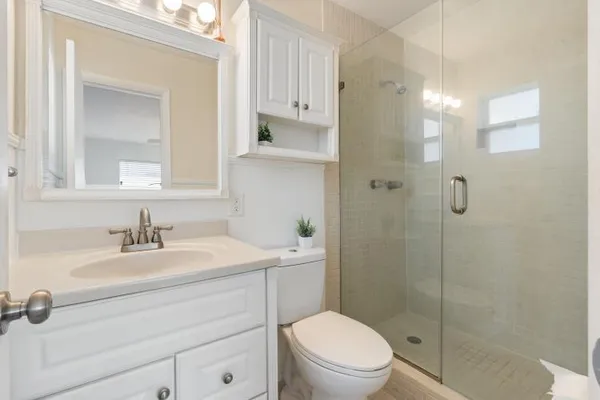 a bathroom with a sink a toilet and shower