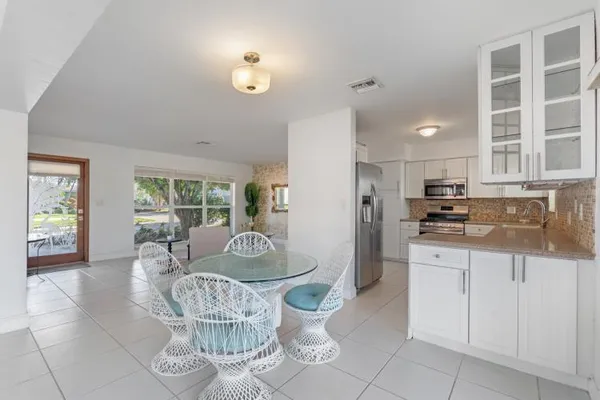 a dining room with furniture and a large window
