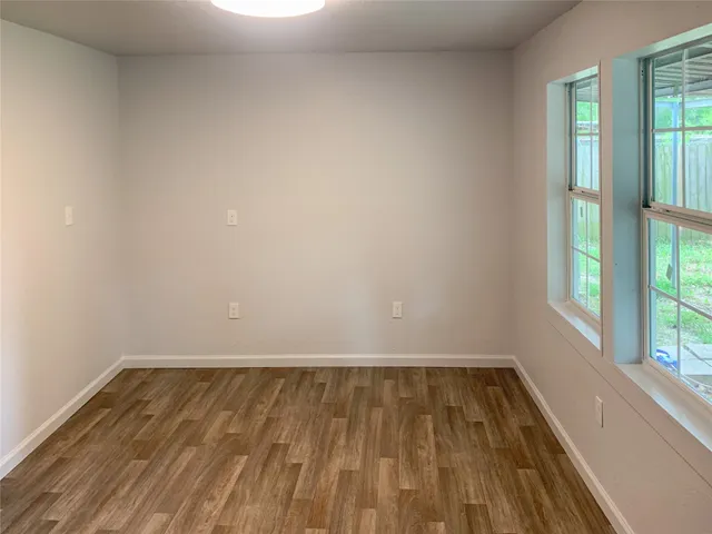 a view of wooden floor and windows in a room