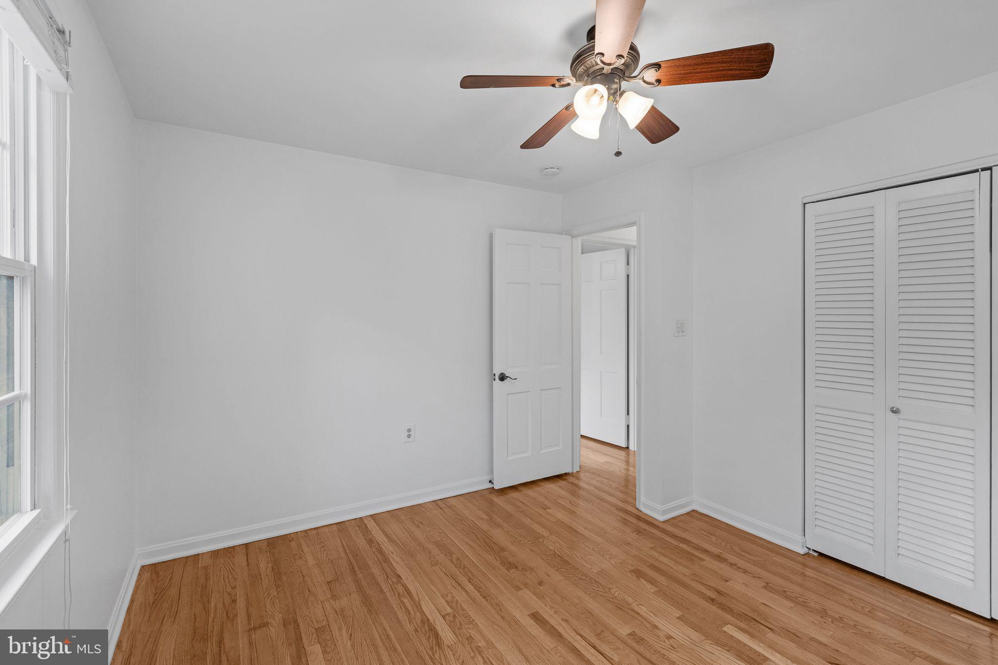 1772 Dryden Way Crofton, MD 21114 - Photo 15 of 34 an empty room with wooden floor chandelier fan and windows
