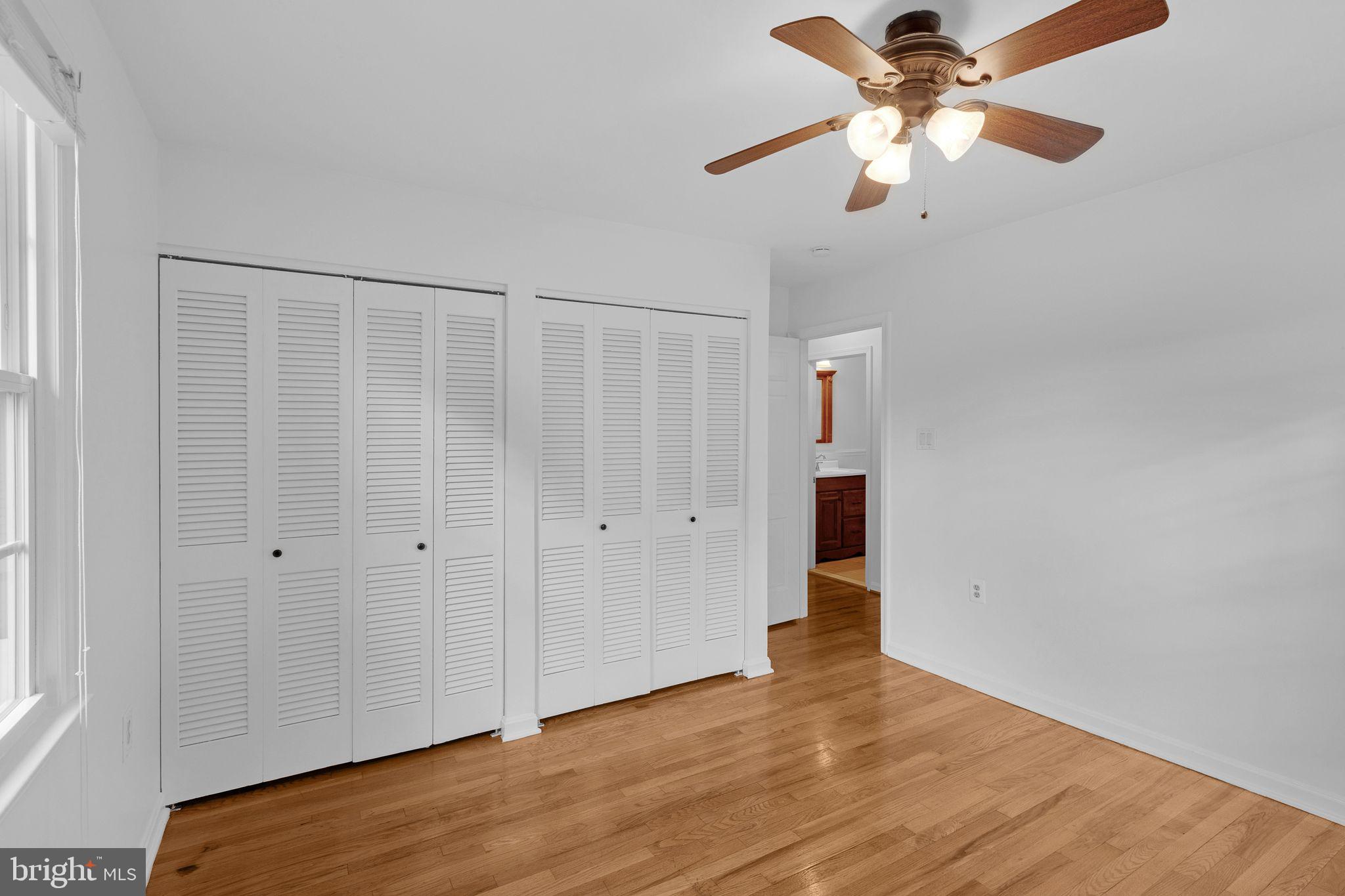 1772 Dryden Way Crofton, MD 21114 - Photo 21 of 34 an empty room with wooden floor chandelier fan and closet