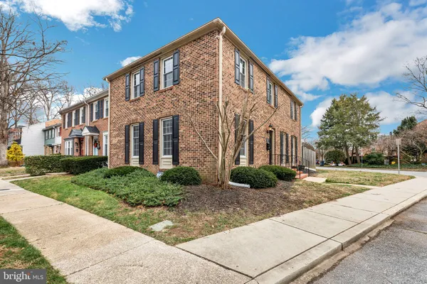 a view of a brick house with many windows next to a yard