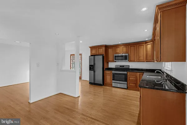 a kitchen with granite countertop a refrigerator and a stove top oven