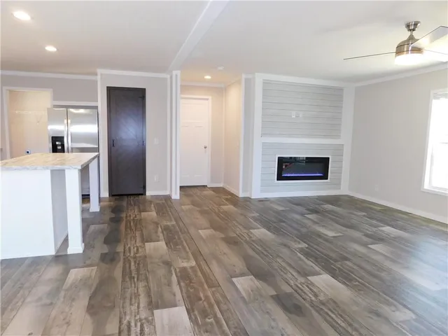 a view of empty room with kitchen and fireplace