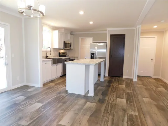 a kitchen with stainless steel appliances a refrigerator sink and microwave
