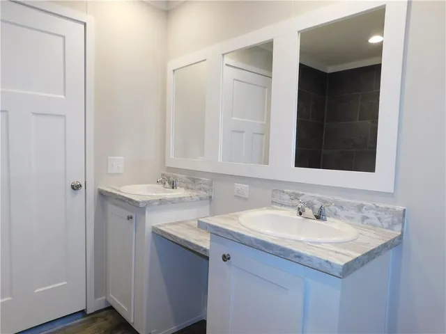 an empty room with wooden floor and fan
