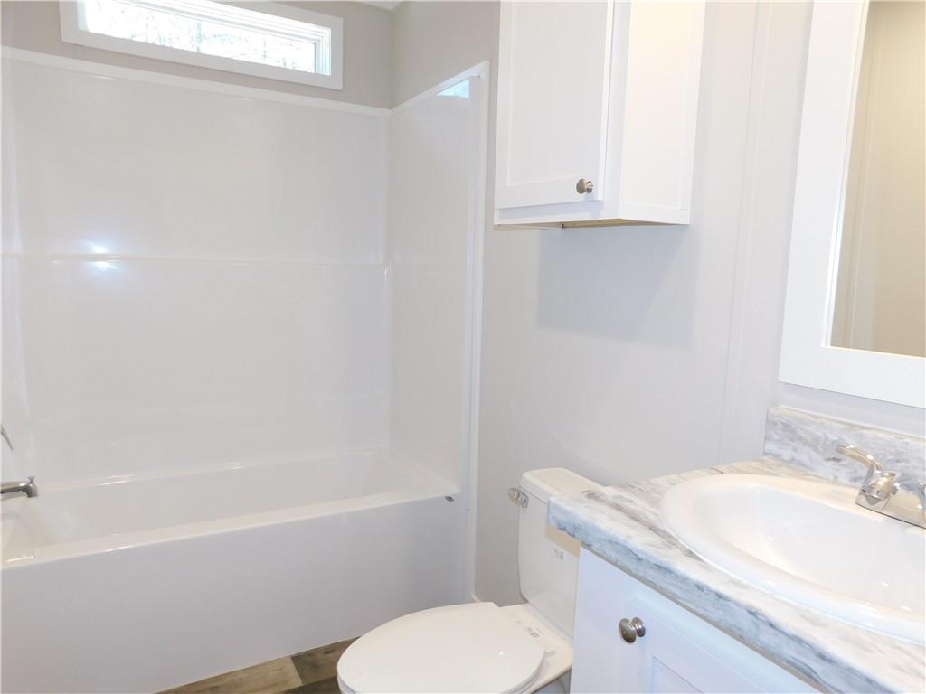 350 Galahad Road Dahlonega, GA 30533 - Photo 32 of 39 a bathroom with a granite countertop toilet sink and mirror