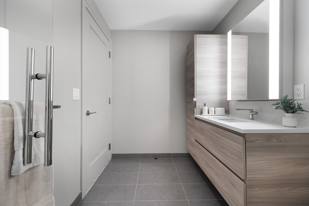 135 Seaport Boulevard, Unit 1902 Boston, MA 02210 - Photo 32 of 40 a bathroom with a double vanity sink and mirror