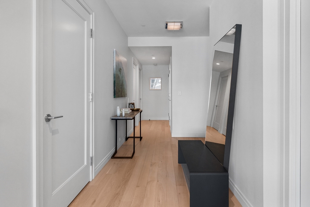 135 Seaport Boulevard, Unit 1902 Boston, MA 02210 - Photo 33 of 40 a view of a hallway with a furniture and a mirror