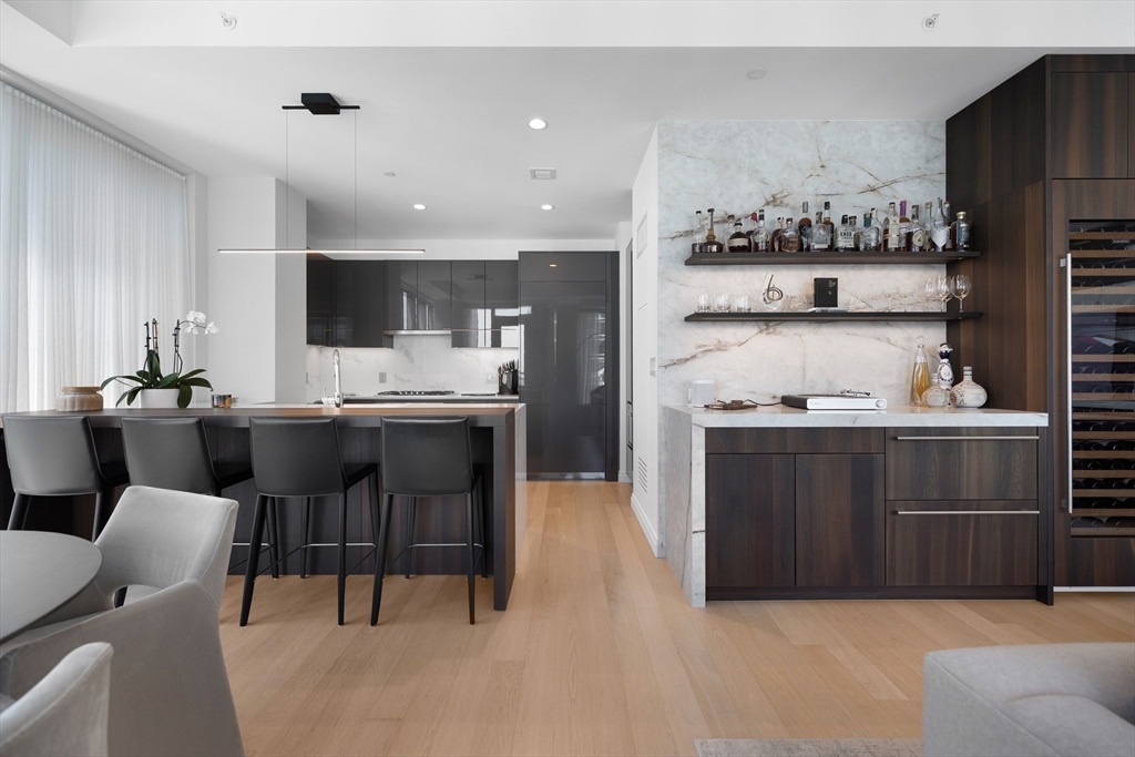 135 Seaport Boulevard, Unit 1902 Boston, MA 02210 - Photo 10 of 40 a kitchen with stainless steel appliances kitchen island granite countertop a sink and cabinets