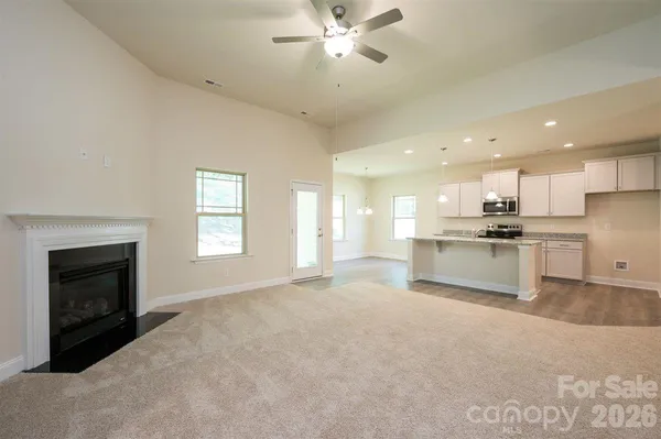 a view of kitchen with granite countertop a sink and white cabinets