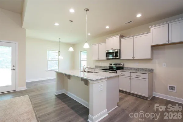 a kitchen with kitchen island a sink stainless steel appliances and cabinets