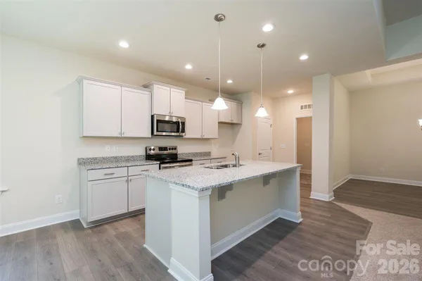 a bathroom with a granite countertop sink a light fixture and a mirror
