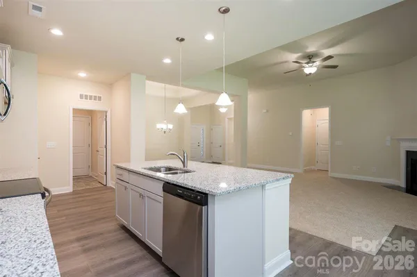 a kitchen with kitchen island a sink stainless steel appliances dining table and chairs