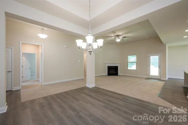 an empty room with windows and fireplace
