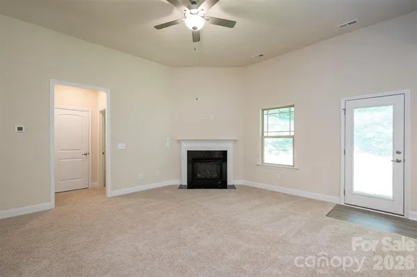 an empty room with fan and entrance