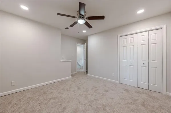 an empty room with a ceiling fan and a window