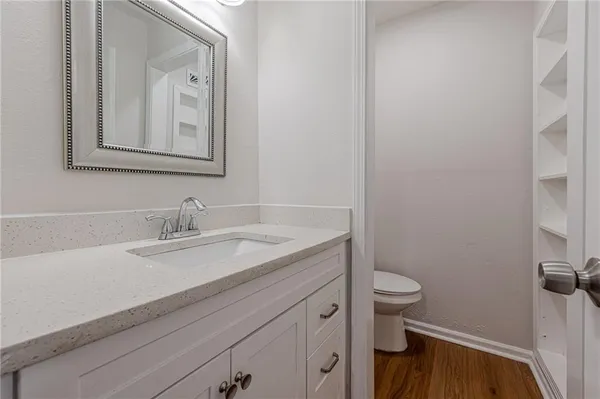 a bathroom with a granite countertop toilet sink and mirror