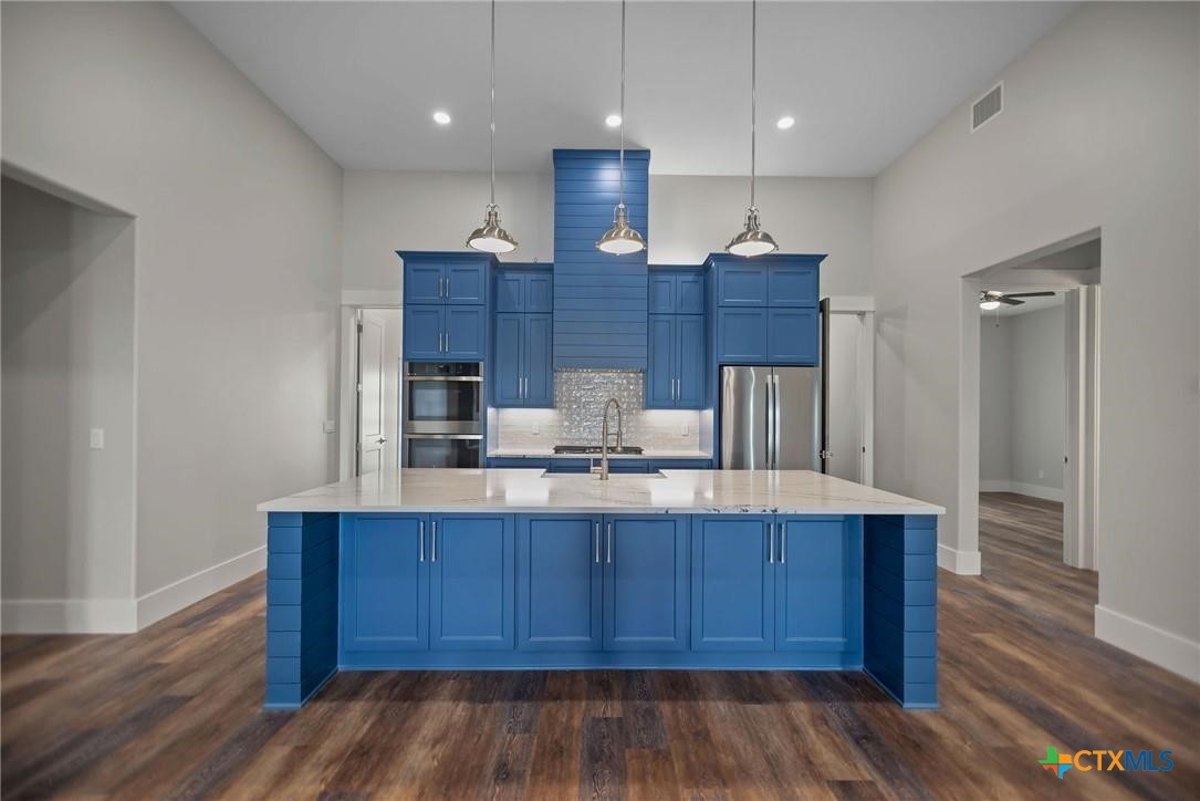 2062 Harrison Avenue Port O'Connor, TX 77982 - Photo 11 of 48 a kitchen with wooden floors and wooden cabinets