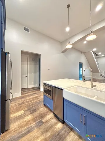 a kitchen with stainless steel appliances granite countertop a sink and a refrigerator