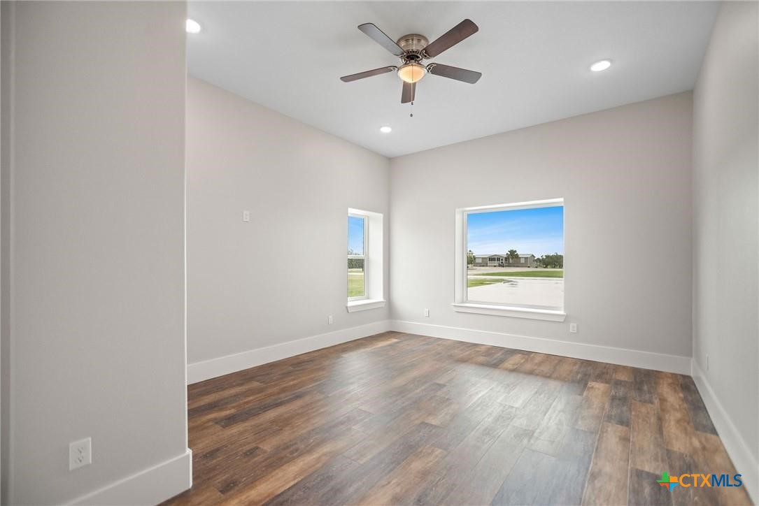 2062 Harrison Avenue Port O'Connor, TX 77982 - Photo 32 of 48 an empty room with wooden floor and windows